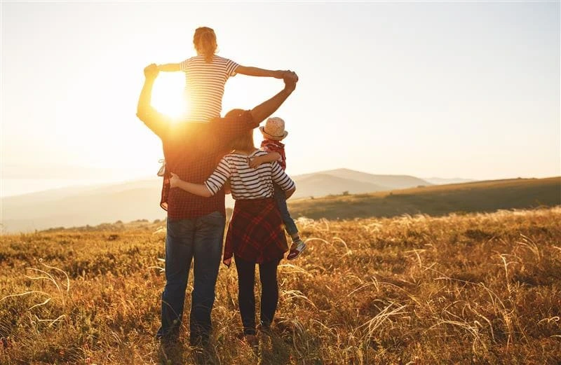 A family looks at the sunset in a field. Top 8 Hospitality Trends in 2025 - Sabre Hospitality