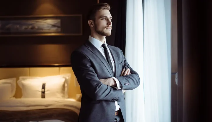 Hotelier in suit looking out window