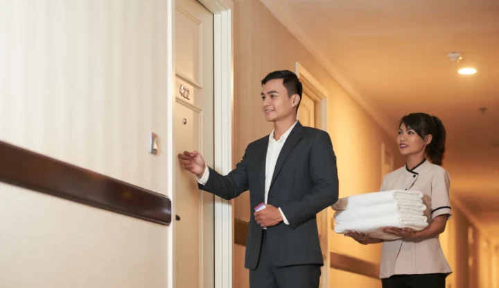 Best Hotel Management System - Hotel manager with housekeeper bringing fresh white towels to a room - Sabre Hospitality